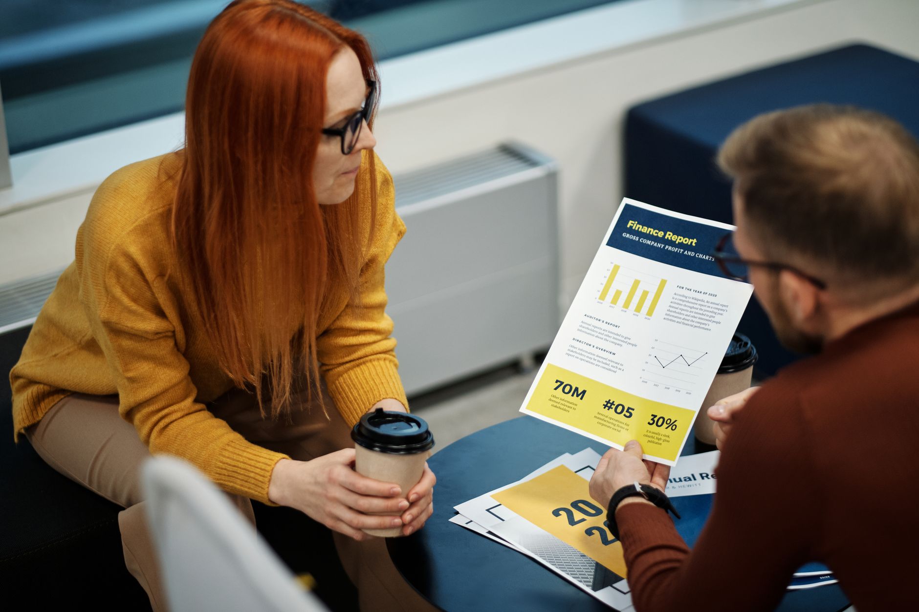 Two colleagues reviewing a printed report across a table